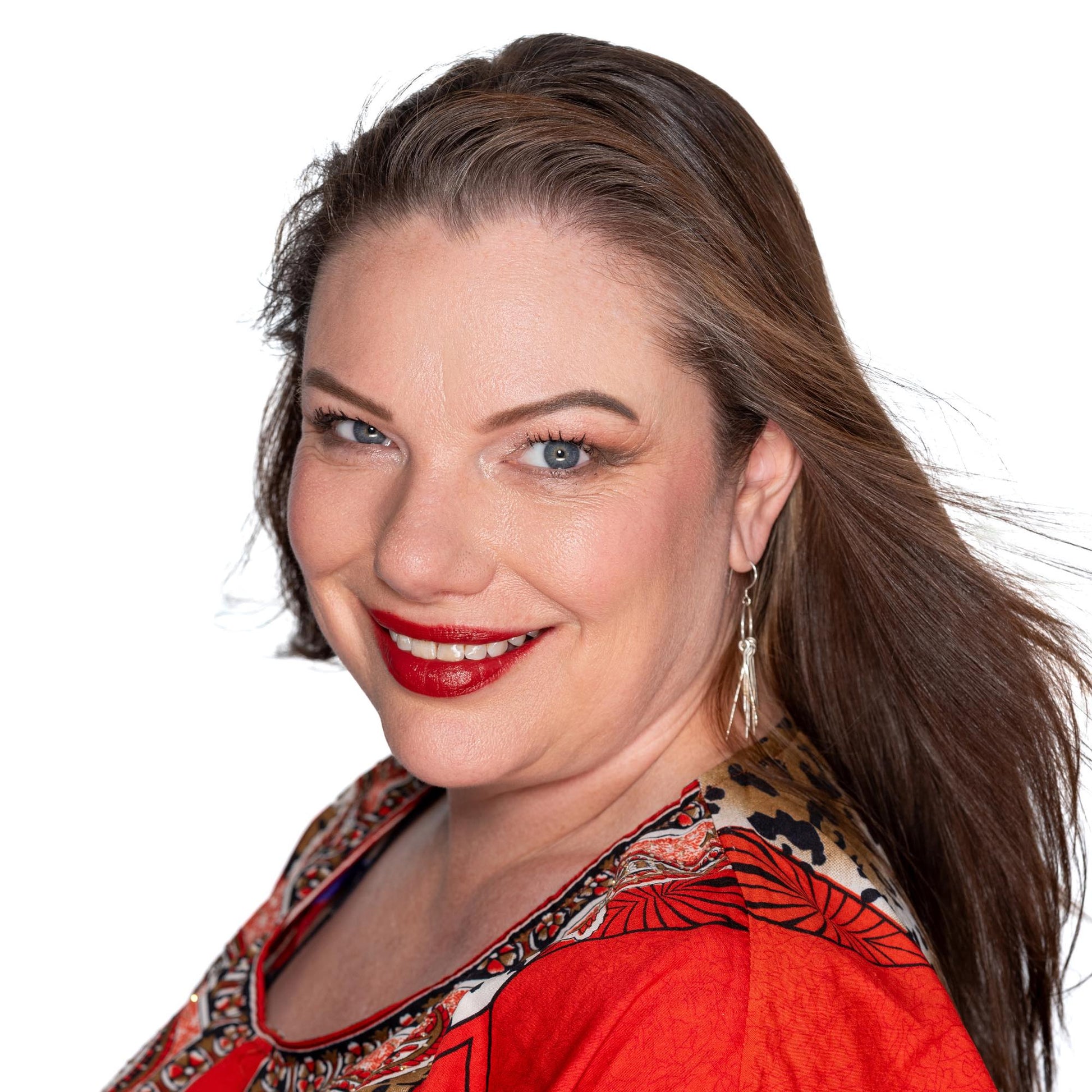 Brunette on white back ground wearing red kaftan brick red orange based red lipstick