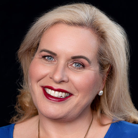 Blond woman on black ground wearing emanare lipstick, ravishing foundation, walnut eyebrow and hope blush