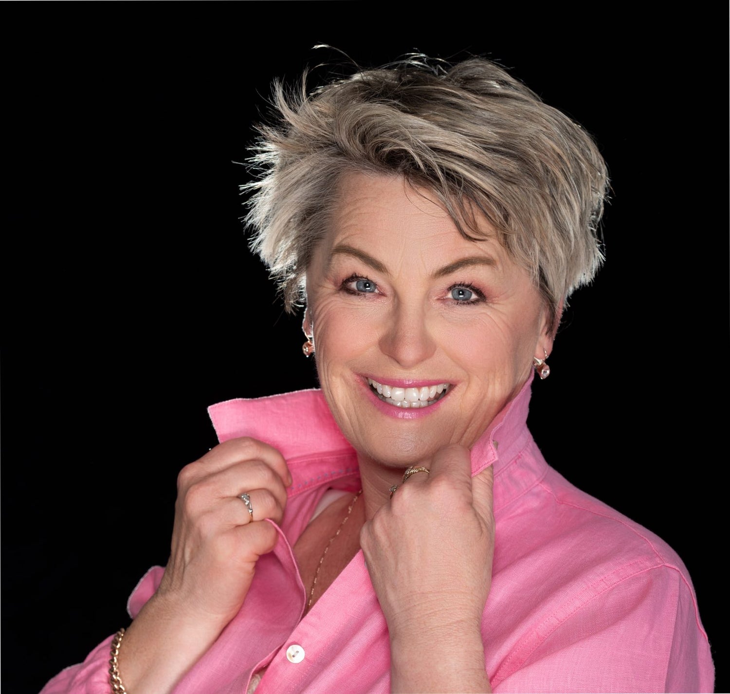 Woman in pink on black back ground wearing rose waltz lipstick