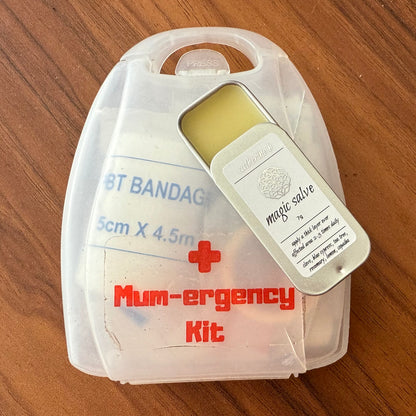 Mum-ergency kit with bandages and salve on a wooden surface