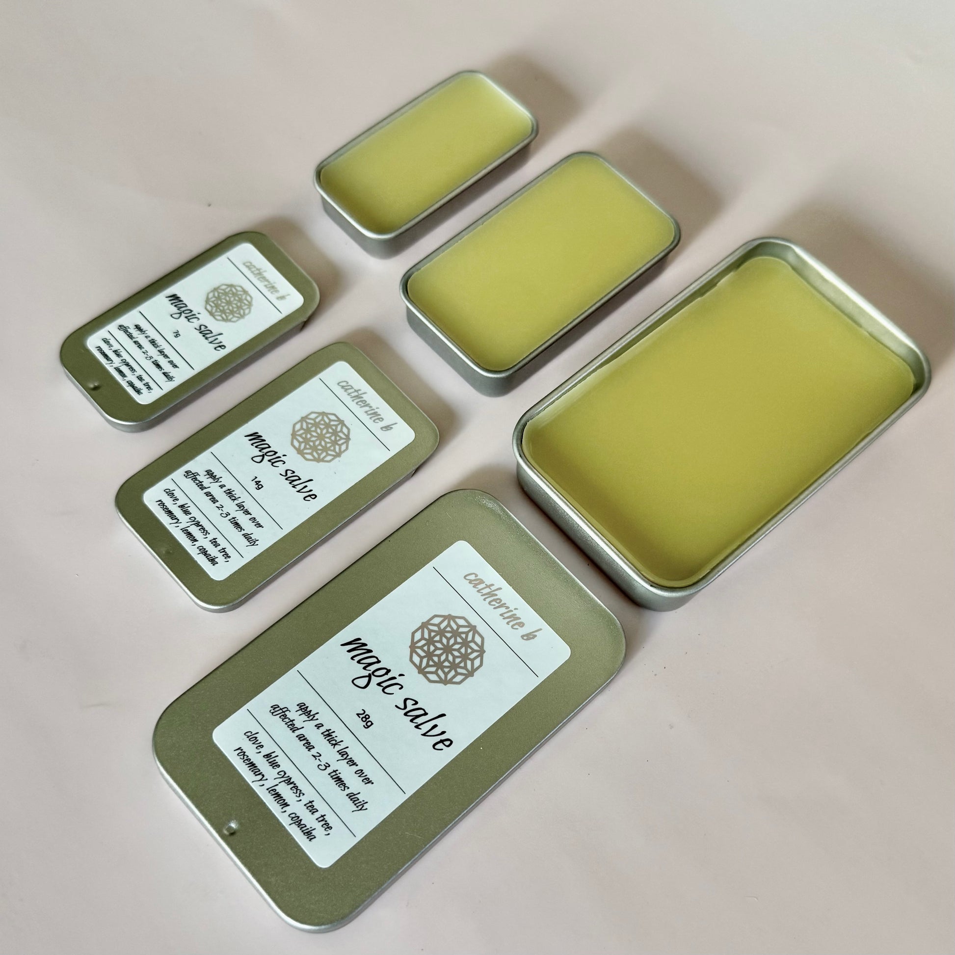 Set of tins with 'magic salve' labels on a beige background