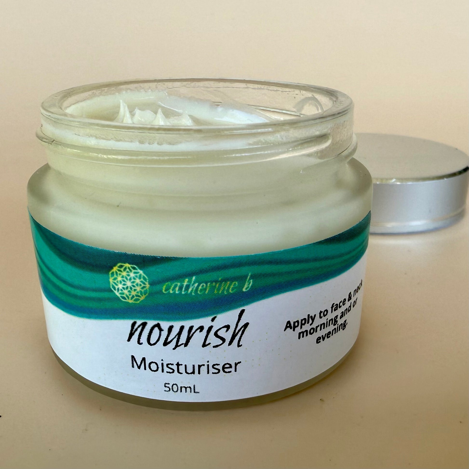 Jar of 'nourish' moisturizer with a visible brand name on a beige background