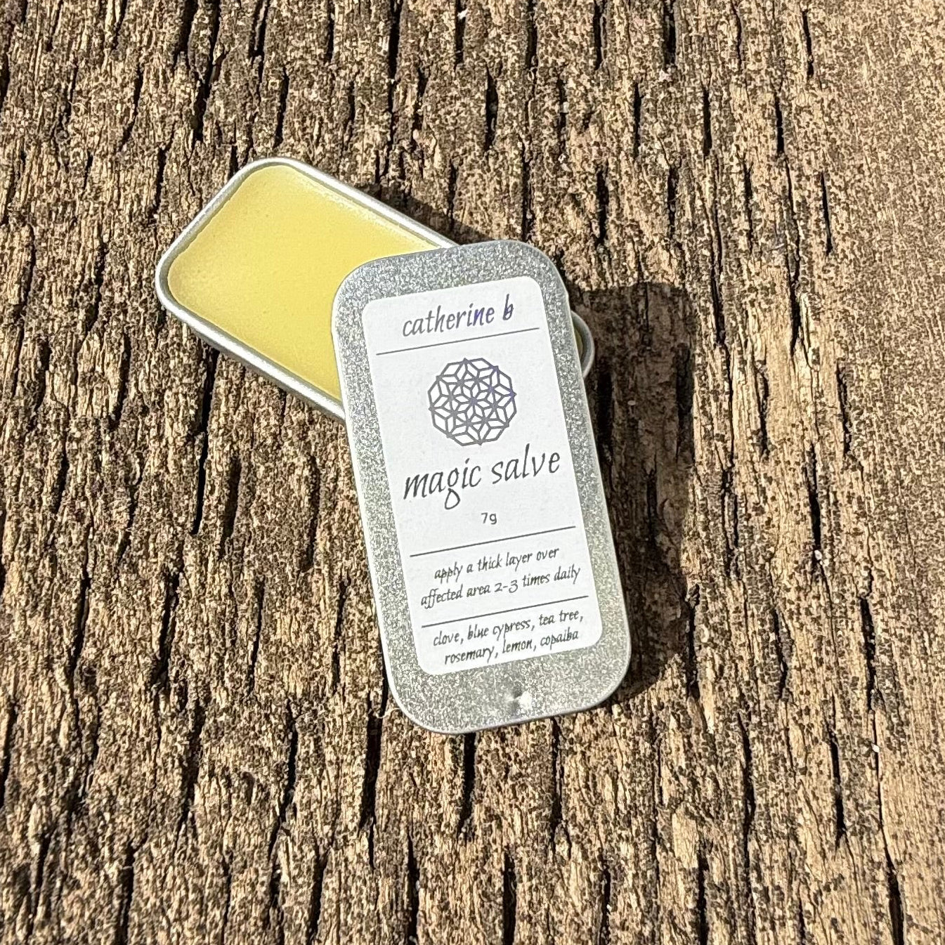 Two small magic salve tin on a wooden surface