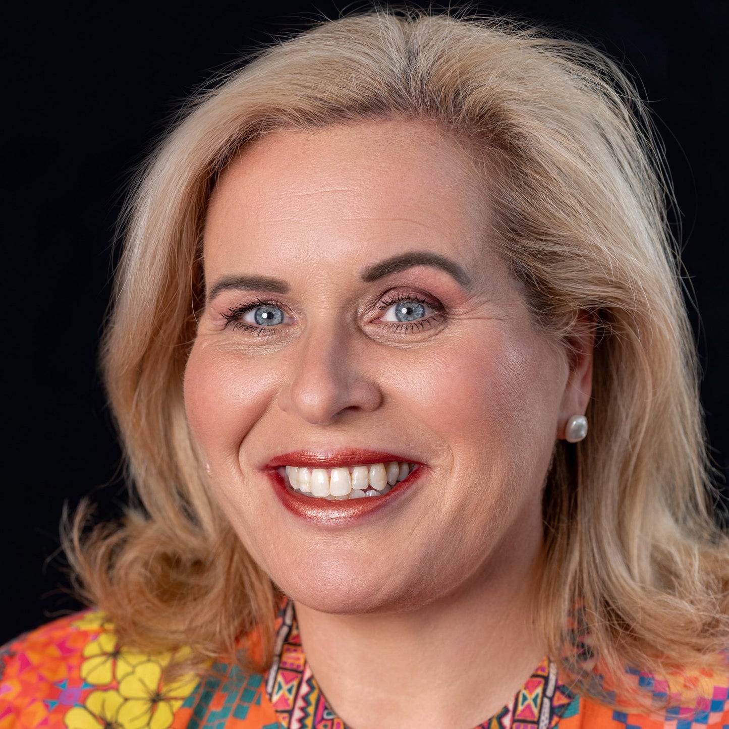 Blonde woman on black background wearing ash brown walnut eyebrow pomade